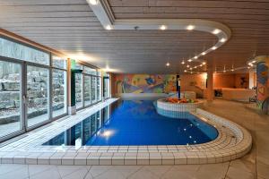 a large swimming pool in a building with a swimming pool at HerzogsPark Apartments mit oder ohne Küche in Herzogenaurach