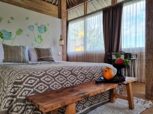um quarto com uma cama grande e um banco de madeira em Stay at My Place Bali em Canggu