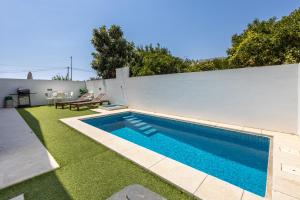 a swimming pool in the backyard of a house at Villa Figo in Luz de Tavira