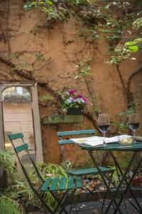 a table with two chairs and two glasses of wine at B&B In Bruges in Bruges