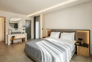 a bedroom with a large bed and a bathroom at Neapolis 21 Suites, Premium Key Collection in Skiathos Town