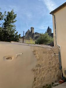 a view of a castle from behind a wall at Studio pour 2 avec terrasse au pied de la Cité : ma pierre à l’édifice in Carcassonne