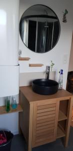 ein Bad mit einem Waschbecken und einem Wandspiegel in der Unterkunft Appartement au pied du port de St Quay Portrieux in Saint-Quay-Portrieux