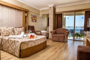 een kamer met een bed, een bank en een stoel bij LAUR HOTELS Experience & Elegance in Didim