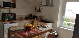 een kleine keuken met een tafel en een vaatwasser bij Appartement au pied du port de St Quay Portrieux in Saint-Quay-Portrieux