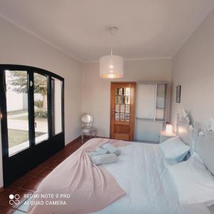 - une chambre avec un grand lit blanc et une fenêtre dans l'établissement Casa Além Rio - quartos para 6 hóspedes em Santo Tirso, à Santo Tirso