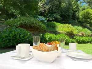 拜奧納的住宿－安特雷里羅伯斯酒店，一张桌子,上面放着一篮面包和酒杯