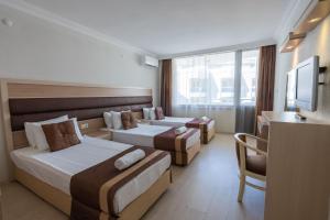 een hotelkamer met 2 bedden en een televisie bij Hotel Caprea in Marmaris