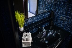 bagno con lavandino nero e specchio di Medius Park Apartment a Sandanski