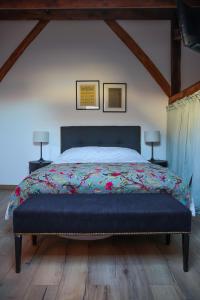 a bedroom with a large bed with a colorful blanket at CROIX BLANCHE - LE LOGIS in Tournan-en-Brie