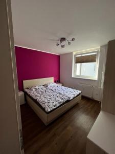 克拉尼斯卡戈拉APARTMA CARPE DIEM的一间带床和紫色墙壁的卧室