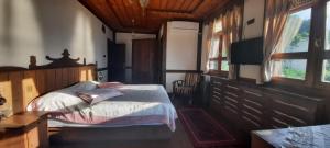 a bedroom with a bed and a flat screen tv at Zümrüdüanka Otel in Rize