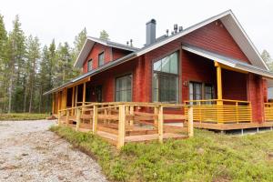 een rood huis met een groot terras aan de zijkant bij Holiday in Lapland - Sointuilevi A73 in Levi