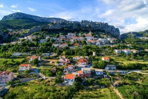 una vista aerea di un villaggio su una collina di Family friendly apartments with a swimming pool Klis, Split - 17987 a Klis