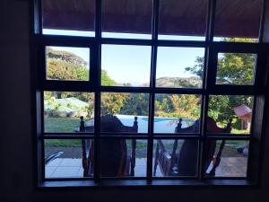 een raam met uitzicht op een tuin vanuit een huis bij Hospedaje Bosque del Río in Monteverde Costa Rica