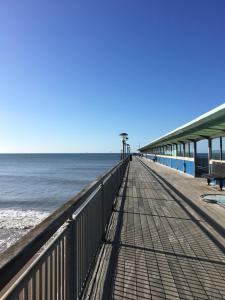 a boardwalk stretches out into the water on a beach at Quirky 1 bedroom Apartment in Boscombe in Bournemouth