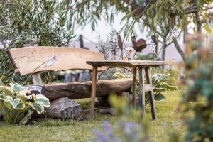 einer Holzbank und einem Tisch im Garten in der Unterkunft Ferienwohnungen in der alten Schnapsbrennerei Kolleritsch in Mureck in Mureck