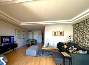 sala de estar con sofá y TV en Parama 003 Secure, Luxurious Waterfront Apartment en Ciudad del Cabo