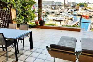 un patio con una mesa y sillas y un puerto deportivo en Parama 003 Secure, Luxurious Waterfront Apartment en Ciudad del Cabo