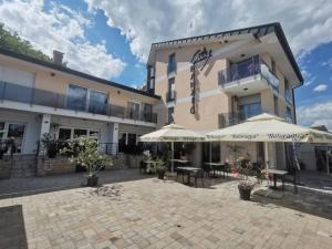 a building with umbrellas and tables in a courtyard at City Apartman ház in Balatonlelle