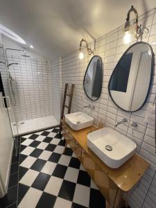 a bathroom with two sinks and two mirrors at Ô Trois Puits in Laburgade