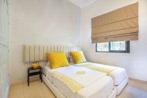 a bedroom with a bed with yellow pillows and a window at Best Apartement For Group In Gueliz in Marrakesh