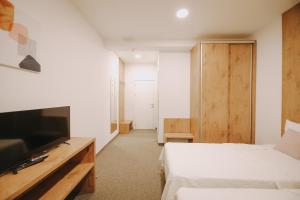Zimmer mit 2 Betten, einem TV und einem Bett der Marke sidx sidx sidx. in der Unterkunft ATOS Centar in Čelinac
