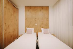twee bedden in een kleine kamer met houten wanden bij ATOS Centar in Čelinac