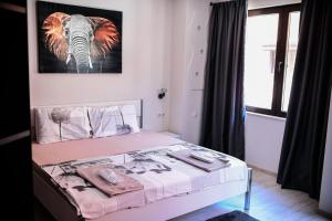a bedroom with a bed with an elephant picture on the wall at Medius Park Apartment in Sandanski