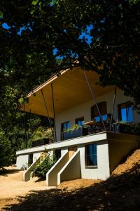 une maison avec une terrasse couverte et des escaliers en face de celle-ci dans l'établissement The cabin Morris, à Holsbeek