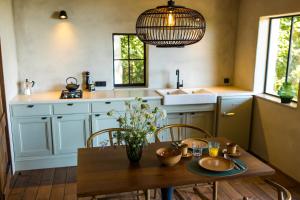 a kitchen with a table and chairs and a sink at The cabin Morris in Holsbeek