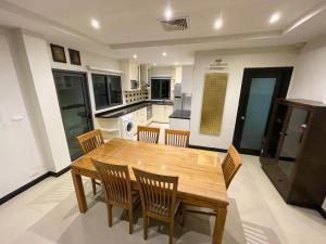 a kitchen and dining room with a wooden table and chairs at Private pool & Jacuzzi villa Pattaya - 600m from beach in Pattaya South