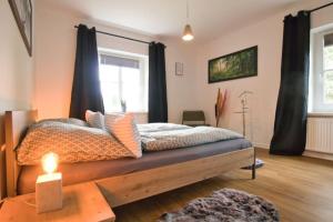 Un dormitorio con una cama y una mesa con una vela en Ferienhaus Haas - Am Heidschnuckenweg, en Faßberg