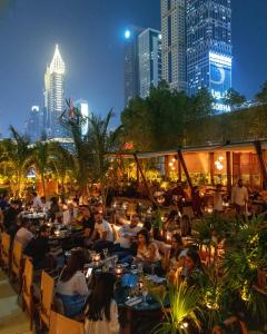 a group of people sitting at tables at a restaurant at Jumeirah Emirates Towers in Dubai
