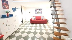 a living room with a red couch on a checkered floor at House of Music - Bari Centro in Bari
