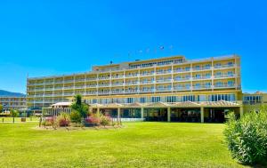 a large hotel with a lawn in front of it at Messonghi Beach Holiday Resort in Moraitika