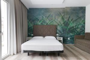 a bedroom with a bed and a green wall at Hotel President in Lido di Jesolo