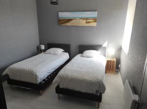 1 dormitorio con 2 camas y una foto en la pared en La maison du Pêcheur, en Grand-Fort-Philippe