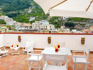 a patio with white tables and chairs and a view at Torre Paradiso in Minori