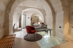 un soggiorno con una sedia rossa e un letto di PIANELLE RESORT a Matera