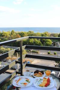 una mesa con 2 platos de comida en el balcón en FALIREON HOTEL, en Atenas