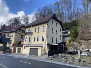 a large house on the side of a street at Waldblickwohnung für bis zu 5P mit Kamin und Sauna in Sebnitz