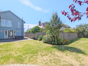 a yard with a fence and a house at Innisfree, Middleton on Sea in Middleton-on-Sea