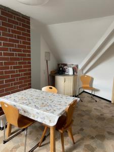 a table and chairs in a room with a brick wall at Casa Andrea 3-Zimmer Wohnung in Wallersdorf