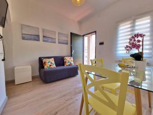 uma sala de estar com uma mesa de vidro e cadeiras amarelas em Ela dream em La Spezia