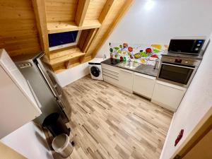 a small kitchen with white cabinets and wooden floors at Familie Ising in Unterwörnitz