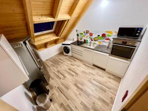 a small kitchen with white cabinets and wooden floors at Familie Ising in Wörnitz