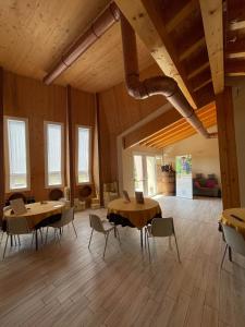a large room with wooden floors and tables and chairs at B&B Le Albare in Montecchia di Crosara