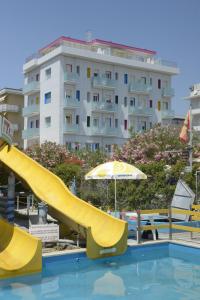 eine gelbe Rutsche in einem Pool mit einem Gebäude in der Unterkunft Residence Hotel Amalfi in Lido di Savio