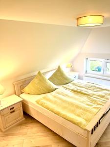 a bedroom with a bed with a yellow comforter at Zur Alten Boddenfischerei Ferienwohnung HeideZauber in Neuendorf Heide